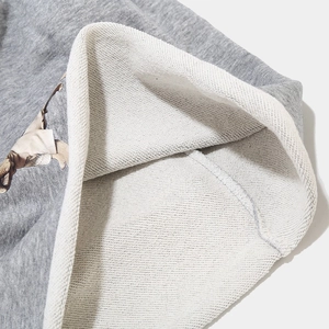 Gros plan détaillé du tissu gris du bonnet montrant la doublure intérieure et coutures