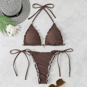 Flat lay of chocolate brown halter bikini with white lettuce trim and vacation props