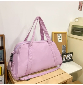 Detail view of a large purple travel duffel bag for gym and sports in a room setting.