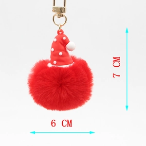 Detail view of red pompom keychain with Santa hat showing 7cm height and 6cm width dimensions