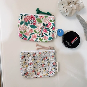 Detailed comparison of two floral cotton coin purses with zippers and brand labels