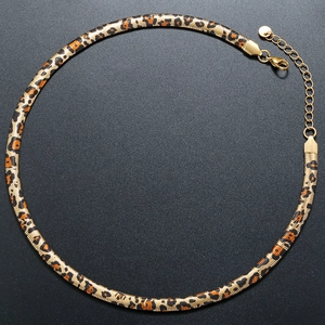 Macro detail of 6mm golden leopard print flat snake chain necklace with lobster clasp