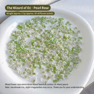Macro shot of 6mm and 8mm resin roses with green leaves and pearls for nail art DIY