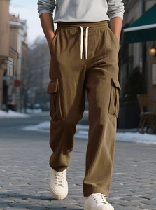 Detail of men's brown corduroy cargo pants with drawstring waist and large side pockets