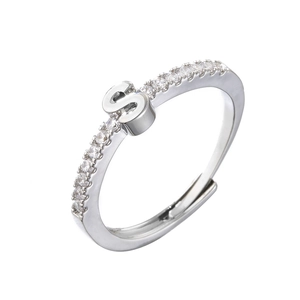 Macro detail of silver ring with letter S design and sparkling zircon pavé setting