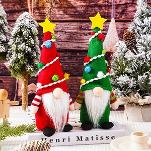 Christmas gnome dolls with red and green hats standing on a decorative holiday scene