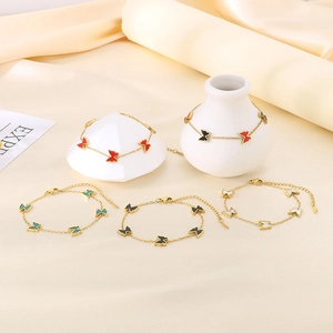 Elegant gold butterfly bracelet with multi-color enamel pendants on silk display