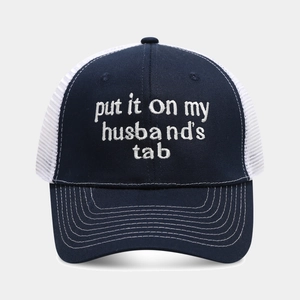 Detailed white embroidery on a navy and white mesh trucker hat with decorative stitching