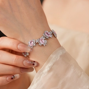 Detailed view of a silver floral bracelet featuring a pink square zircon on the wrist