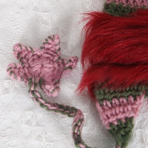 Detail of handmade knit cat ear hat with pink stars and plush red faux fur texture