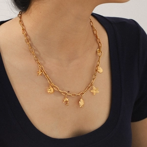 Collier en titane doré avec pendentifs étoile de mer et coquillages sur un mannequin