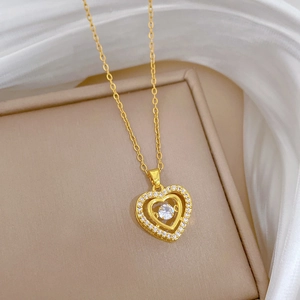 Close-up of golden double heart necklace with sparkling crystals on a silk display