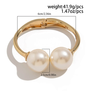 Detail showing oversized pearls and dimensions of golden metal open cuff bracelet