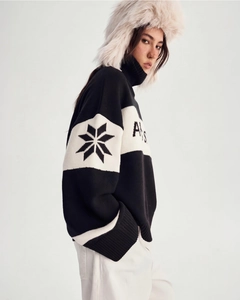 Detailed knit of color-block sweater with snowflake patterns and chunky high neck style