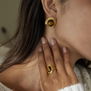 Close-up model view of 18K gold stainless steel earrings with brown tiger eye stone