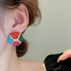 Detailed view of colorful rhinestone-encrusted round stud earrings with gold woven texture