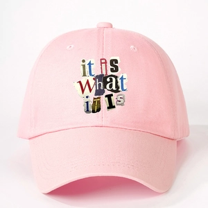 Pink cotton baseball cap featuring an it is WHAT it is collage print and adjustable brim