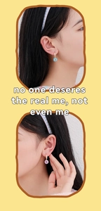 Detail of sweet enamel heart earrings with zircon inlay shown in pink and blue on model