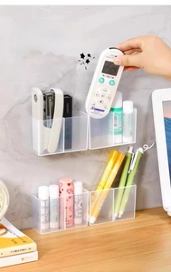 Detail of wall-mounted clear acrylic storage boxes for office and remote control