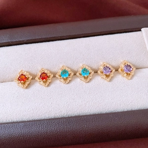 Détail de boucles d'oreilles vintage avec pierres rouges bleues et violettes en plaqué or