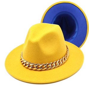 Detail of yellow fedora hat with a bold gold acrylic chain and blue interior lining