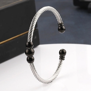 Detail of silver twisted wire stainless steel bracelet with black bead accents