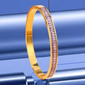 Détail d'un bracelet en acier titane doré orné de zircons violets rectangulaires