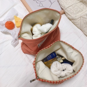 Orange houndstooth cotton makeup bag set with top silver zipper in lifestyle scene