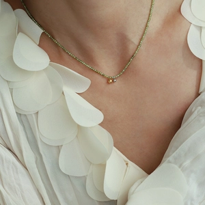 Minimalist olive green beaded choker necklace with gold and silver accents on titanium steel