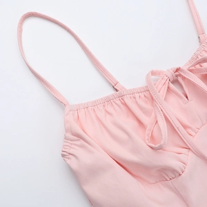 Détail de robe caraco rose avec buste plissé et petit nœud élégant à l'encolure