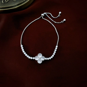 Macro detail of silver-toned flower tennis bracelet with adjustable slide clasp closure