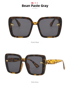 Detail view of large tortoise shell sunglasses with golden metal M-logo on the temple