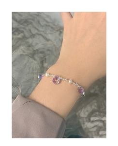 Close-up of S925 silver bracelet with purple drop crystal and white pearls on wrist