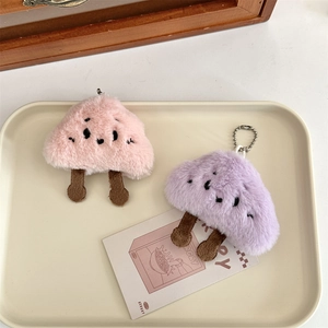 Dettaglio dei ciondoli a forma di fungo in peluche rosa e viola con ricami fini