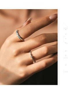 Detail of s925 silver rings set with blue and white zircons on a model's hand