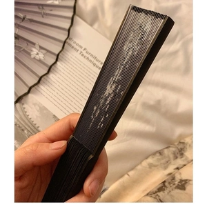 Handheld closed black folding fan with traditional bamboo ribs for dance and photography