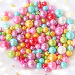 Close-up of high-gloss colorful ABS faux pearls on starry tulle for DIY crafts
