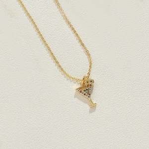 Macro view of gold chain necklace with martini glass pendant and colorful zircon stones