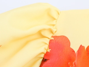 Makroaufnahme von gelbem Blumenstoff mit Fokus auf Nähte und glatte Textur