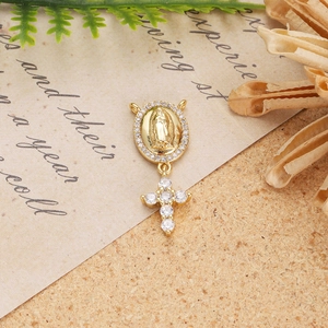 Detail of 18K gold religious pendant with Virgin Mary medal and zircon cross