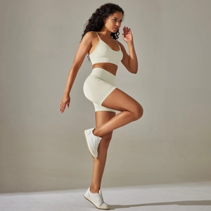 Detail von cremefarbenem nahtlosem Sport-Bra und High-Waist-Shorts an Fitnessmodel