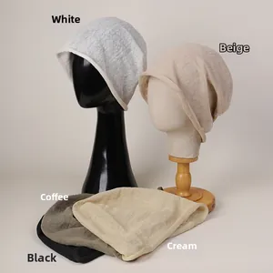 Detail view of five different colors of lightweight linen beanies with rolled edge design