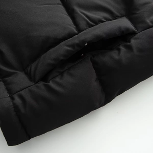 Detailed macro view of quilted black puffer jacket featuring side pocket and seams