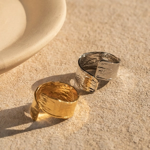 Détail de bagues ajustables en acier inoxydable doré et argenté avec texture martelée