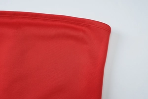 Detailed close-up showing the double-needle stitching and texture of the red knit fabric