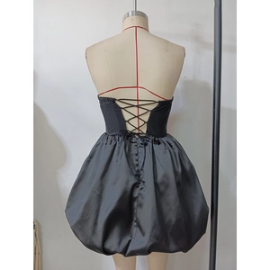 Detail of the cross back lace-up closure on a black strapless bubble hem evening dress