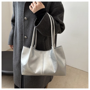 Silver metallic tote bag shown on model wearing grey wool coat for modern look