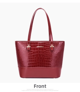 Close-up of wine red tote bag featuring crocodile embossed leather and gold hardware