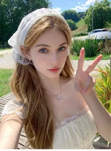 Close-up of intricate white floral lace pattern on the French style head scarf