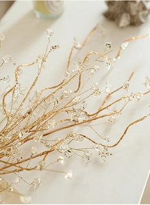 Close-up of gold Christmas branch decoration with glittered star beads and clear drops